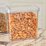 Clear container filled with almonds on a marble surface