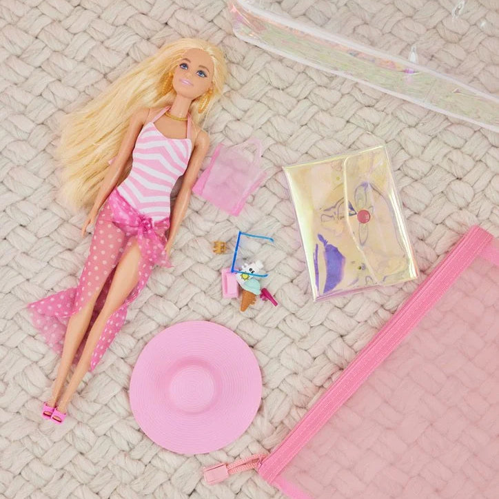 Barbie doll with pink swimsuit and accessories on a textured surface